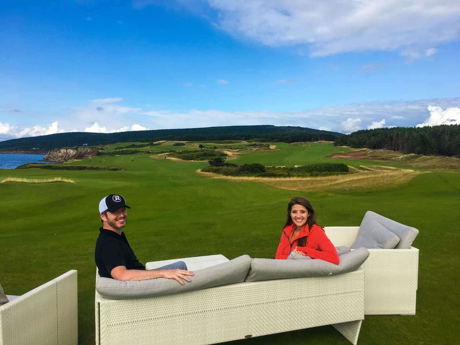 couple sitting on golf course - summer travel guide Cape Breton