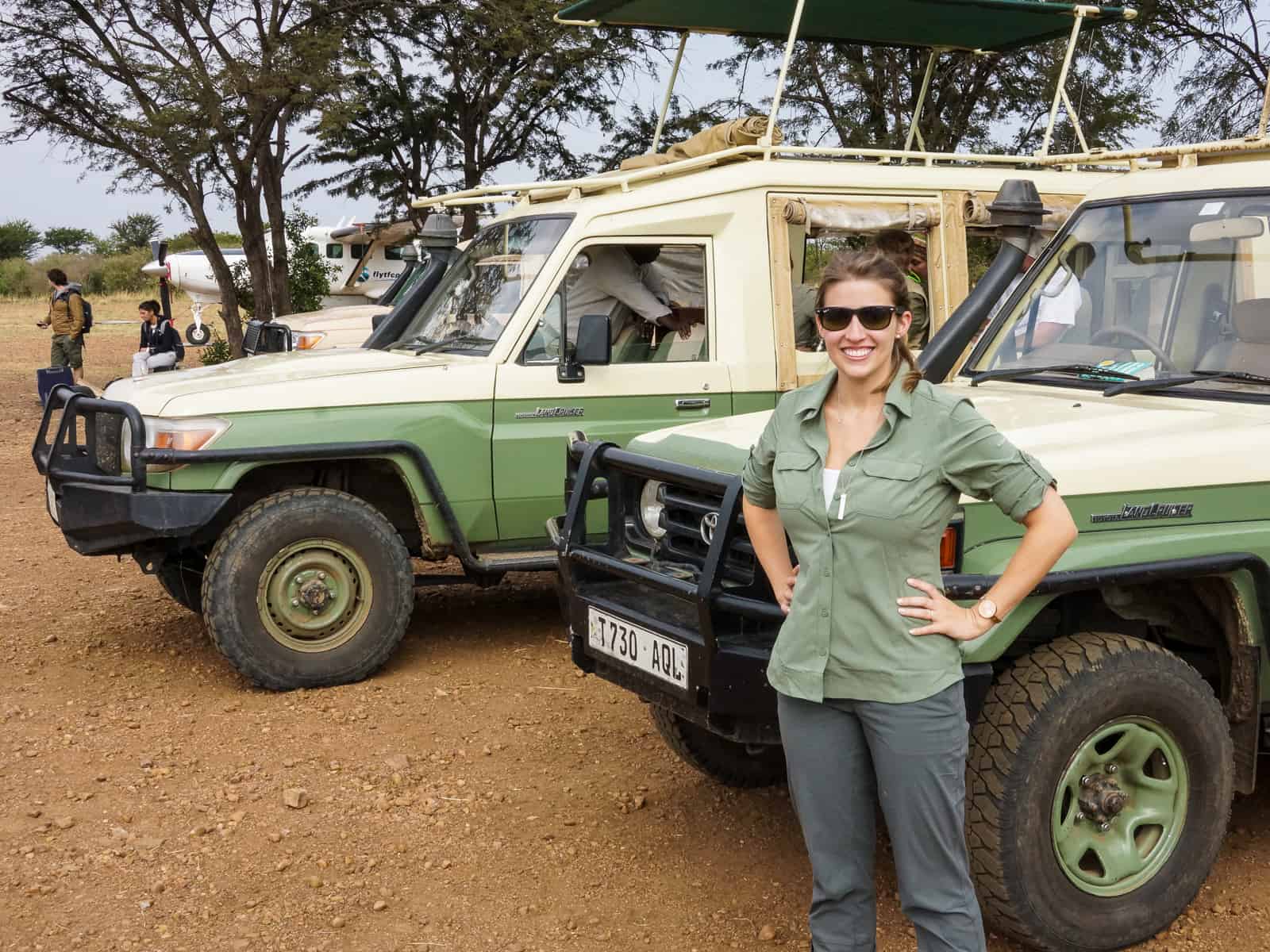 woman next to safari car- Tanzania safari honeymoon guide