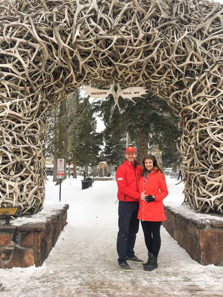 couple posing under the elk arches