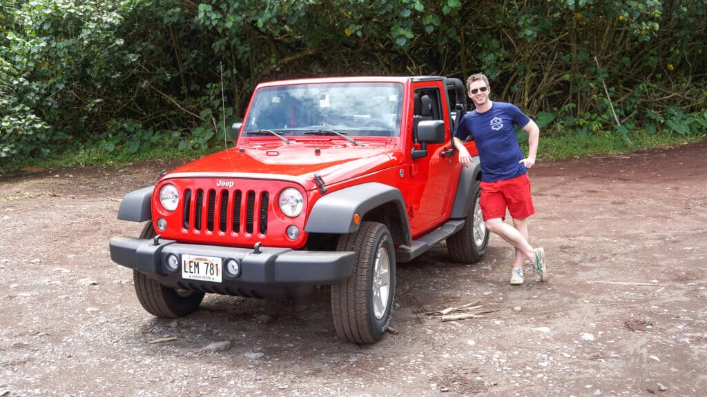 man resting against Jeep Wrangler - ultimate guide to road to Hana