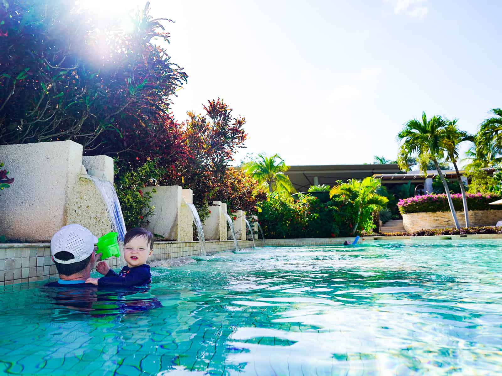 dad in pool with son - rosewood mayakoba luxury family resort