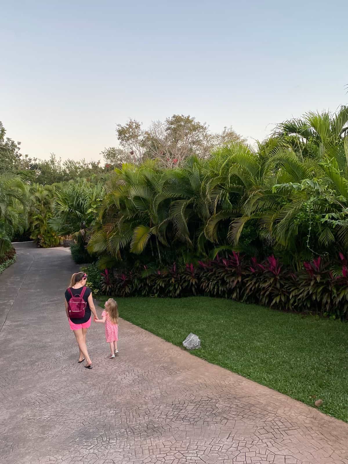 girl and mom walking through rosewood mayakoba luxury family resort
