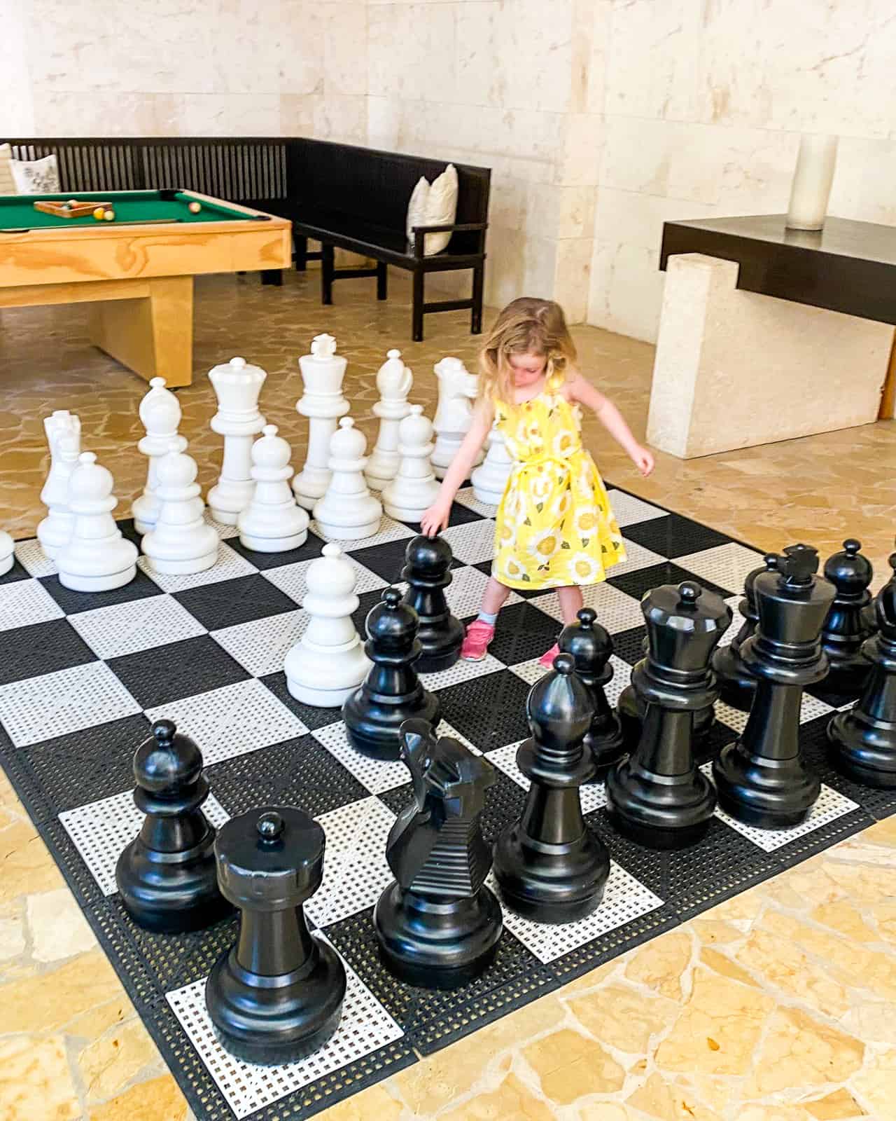 girl playing life sized chess rosewood mayakoba