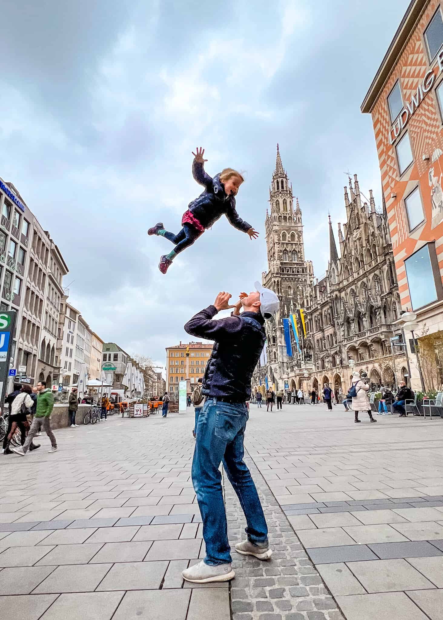 dad throwing daughter in air Marienplatz - Munich with kids