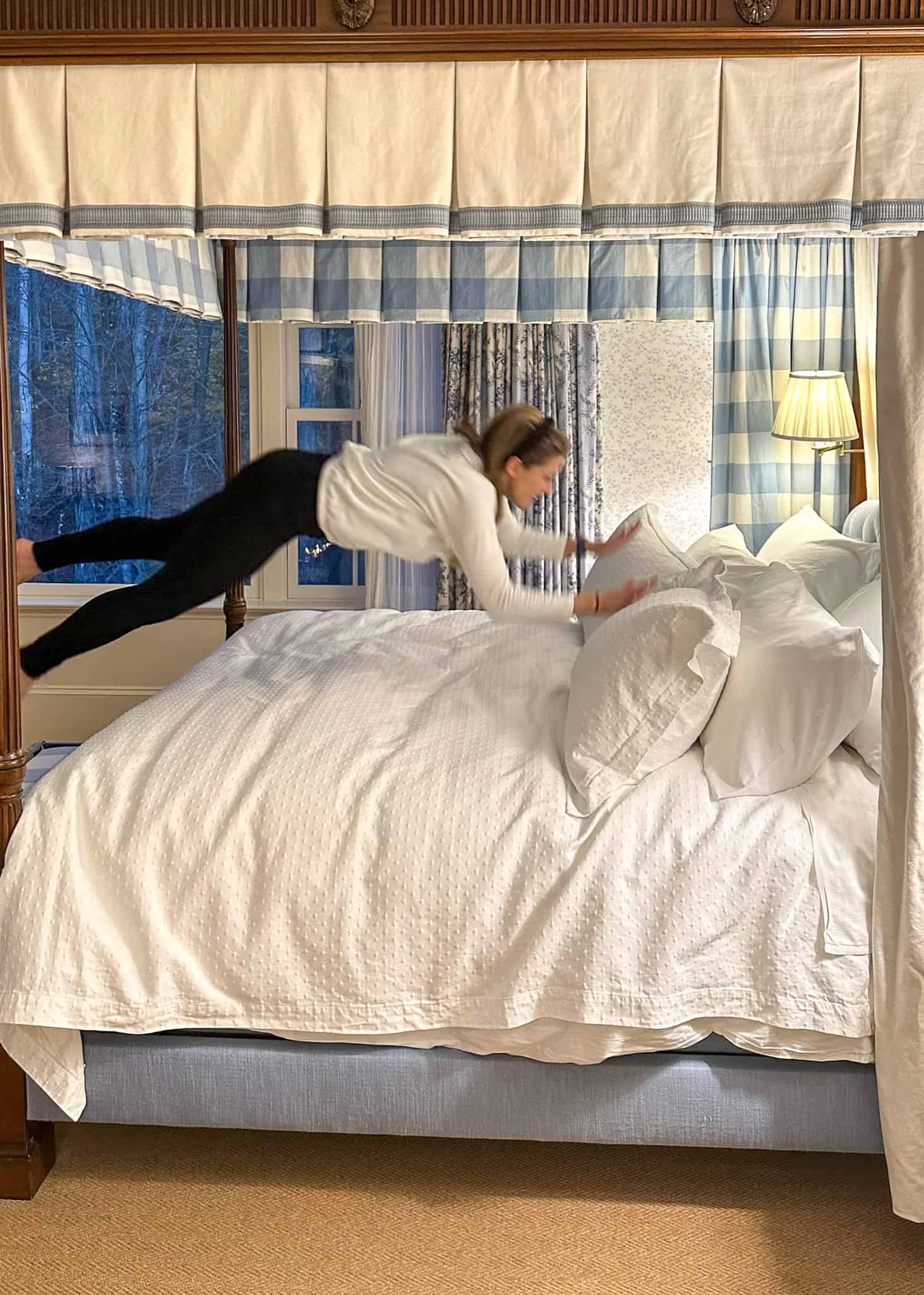 girl jumping onto bed mayflower inn