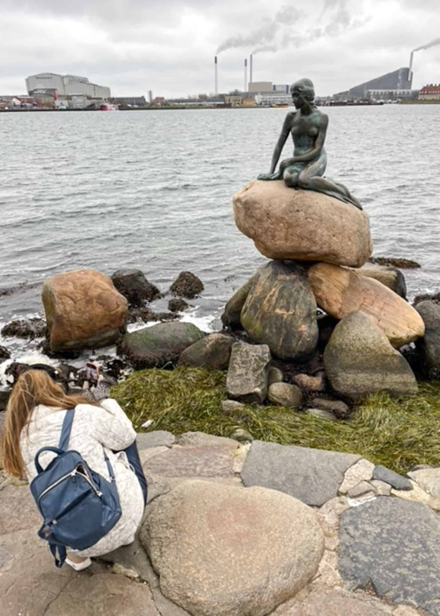 woman taking photo of little mermaid statue - things to do in copenhagen winter