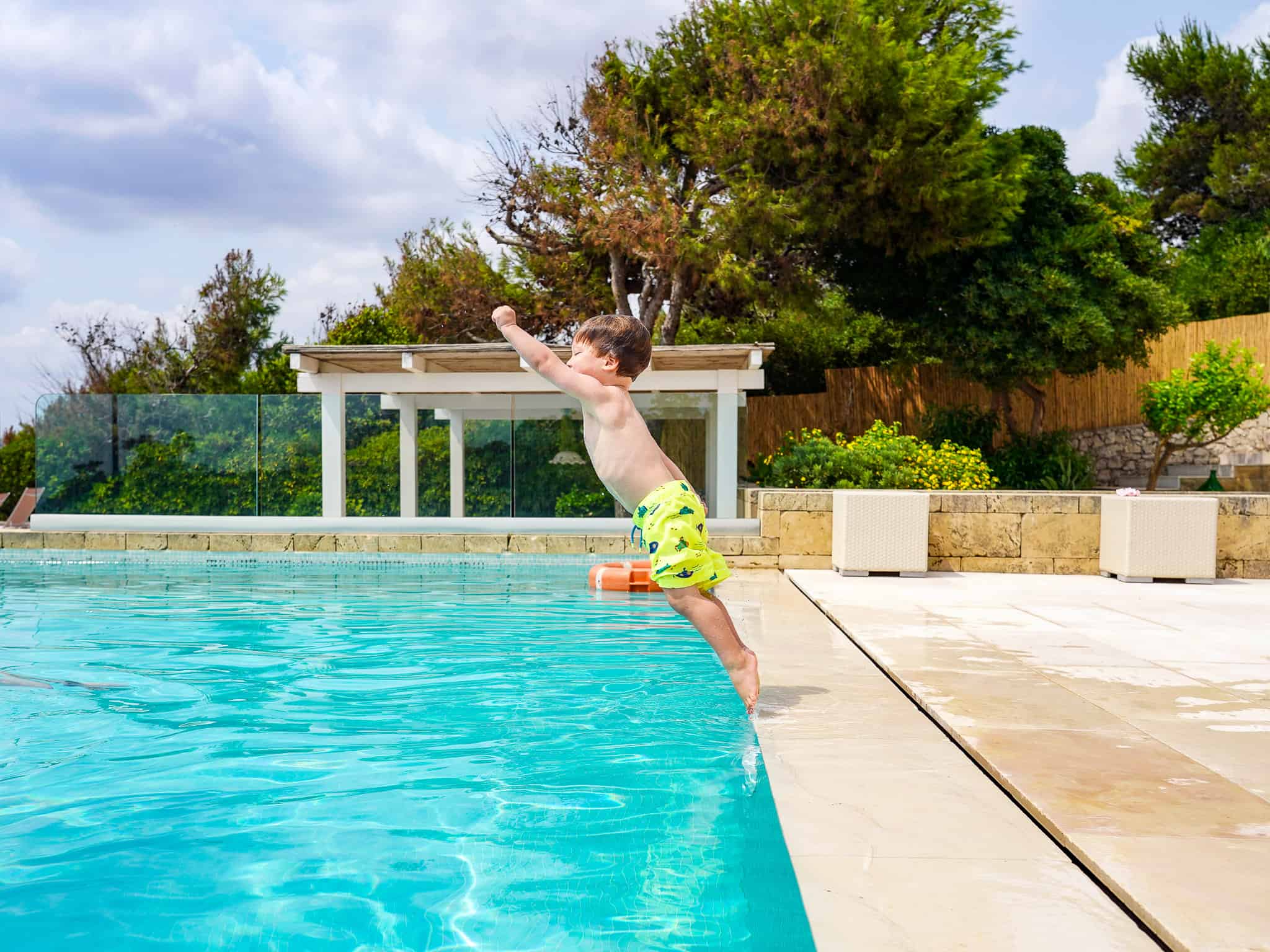 little boy jumping into pool at l'argentiera- villas in puglia