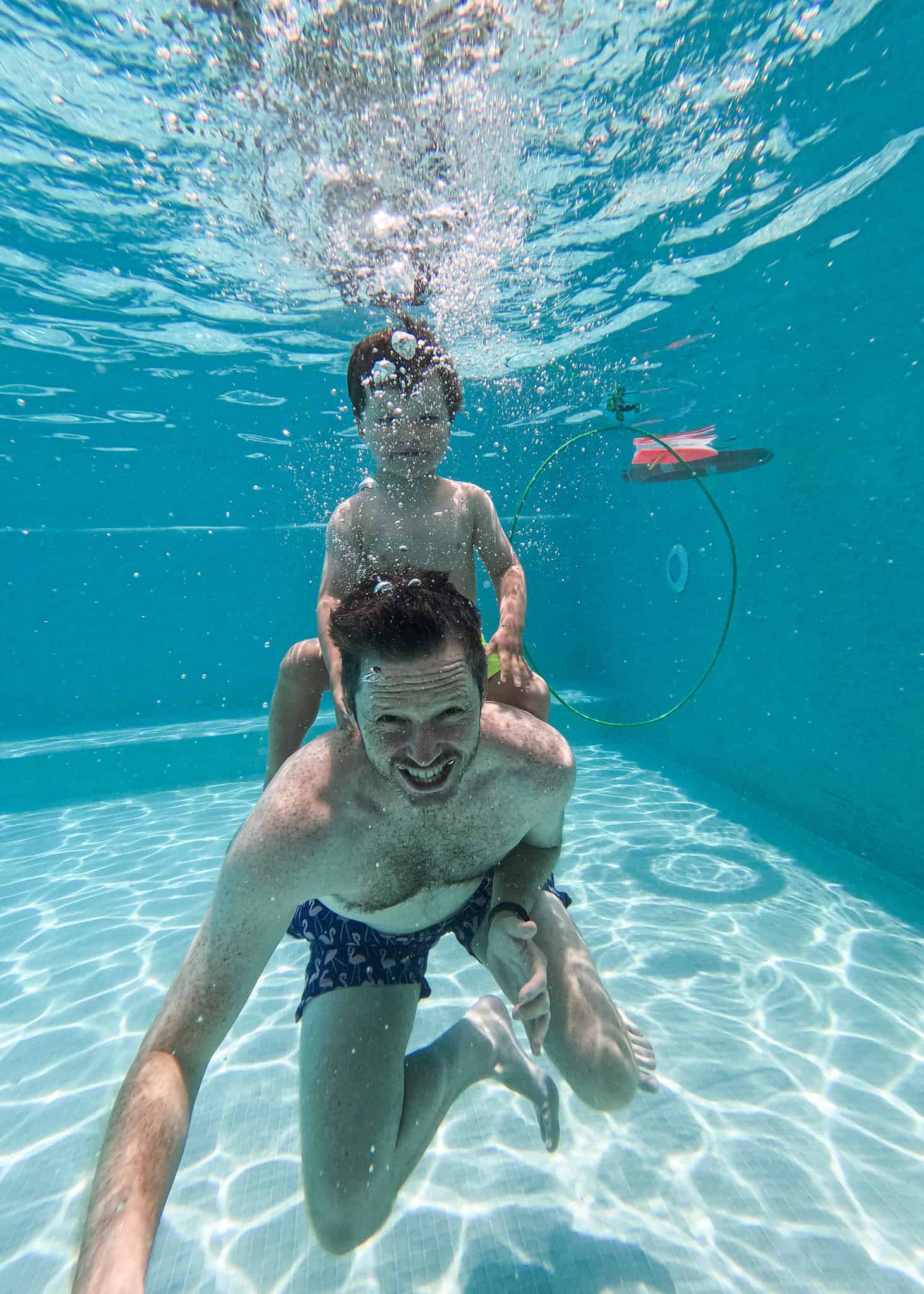 underwater photo of dad and son in pool go pro