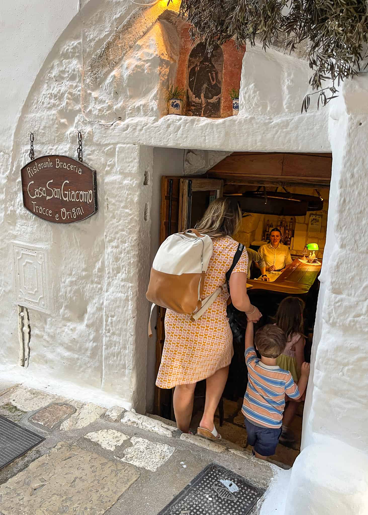 mom and son walking into small restaurant in ostuni