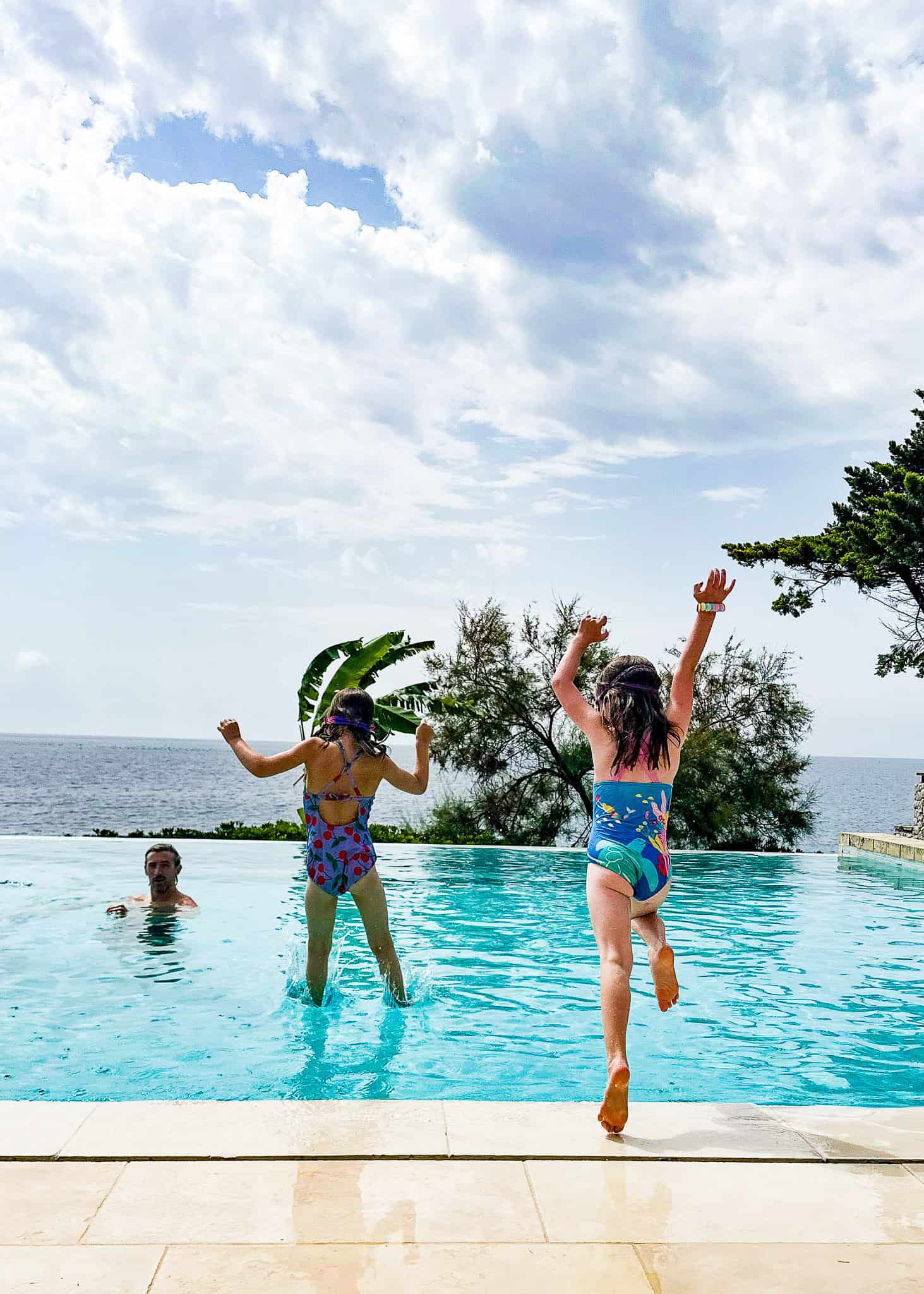 girls jumping into pool at l'argentiera - the thinking traveller villas in puglia