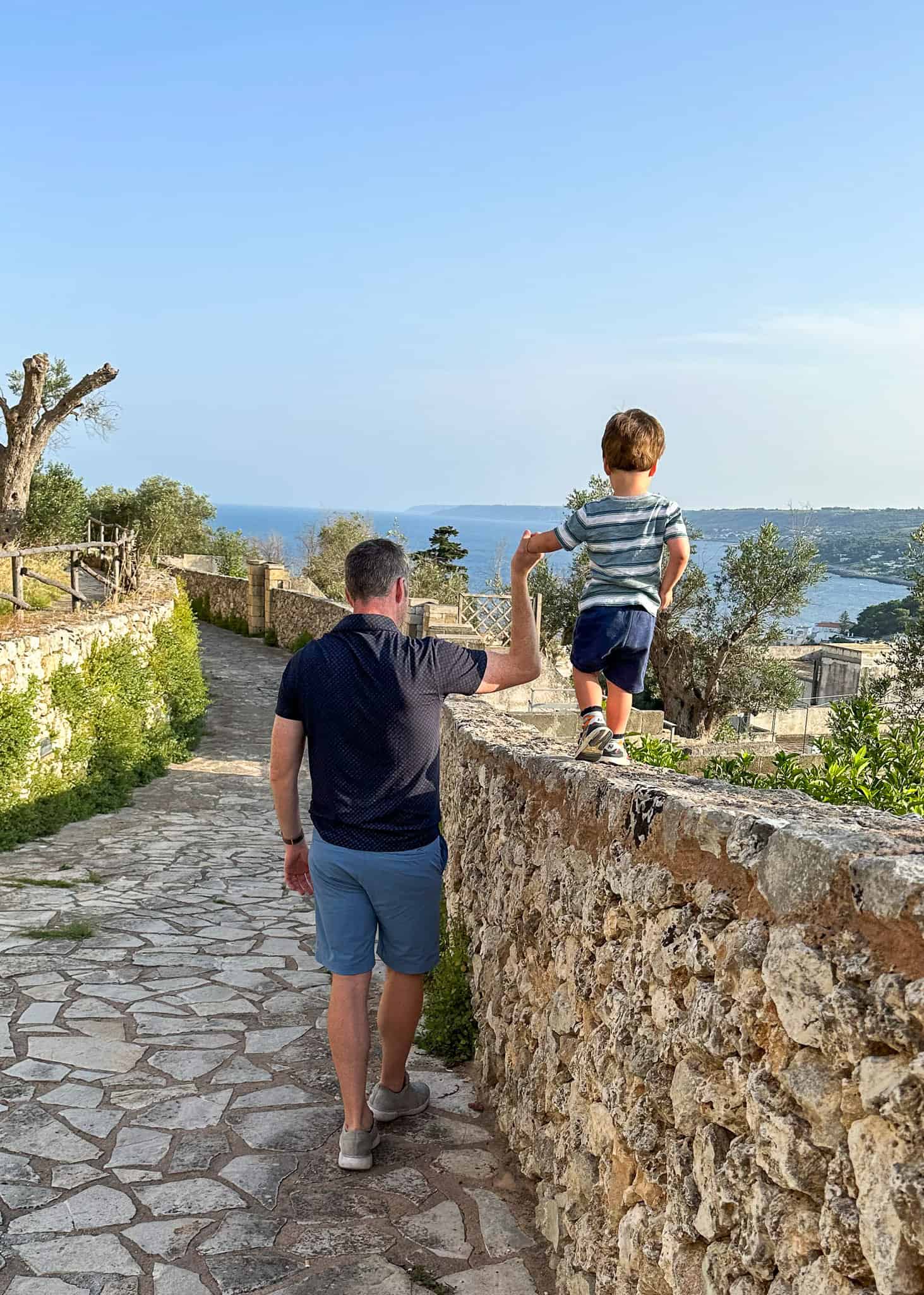 boy and dad walk castle walls in Castro - best places in puglia