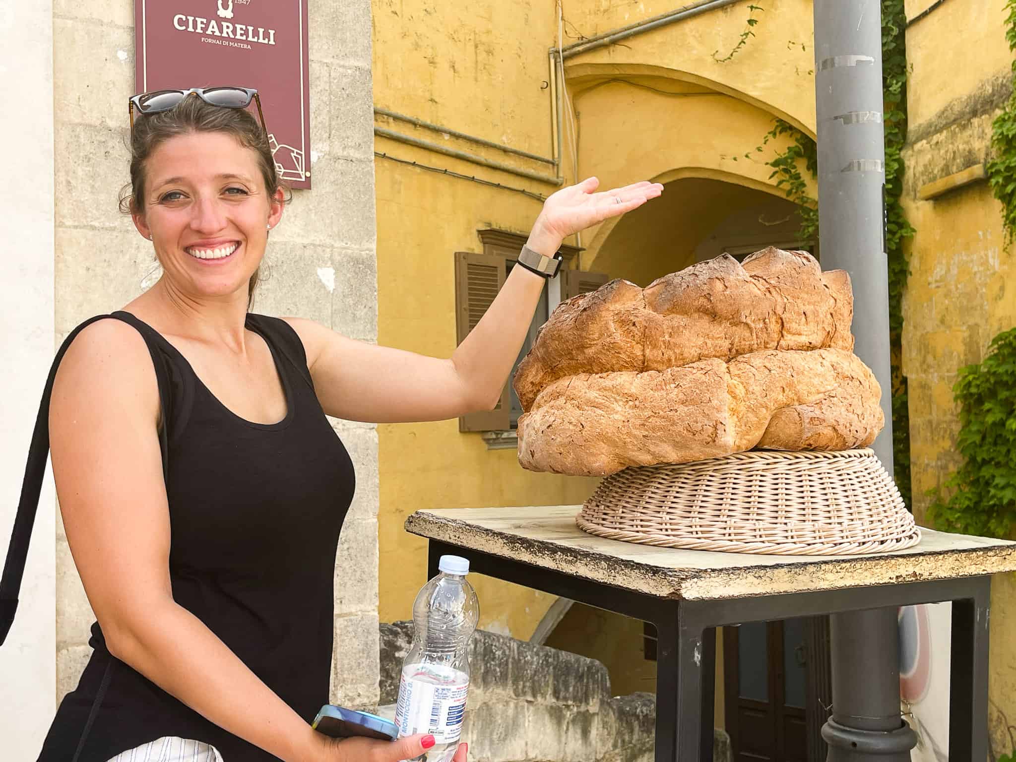 girl in matera with large loaf of bread