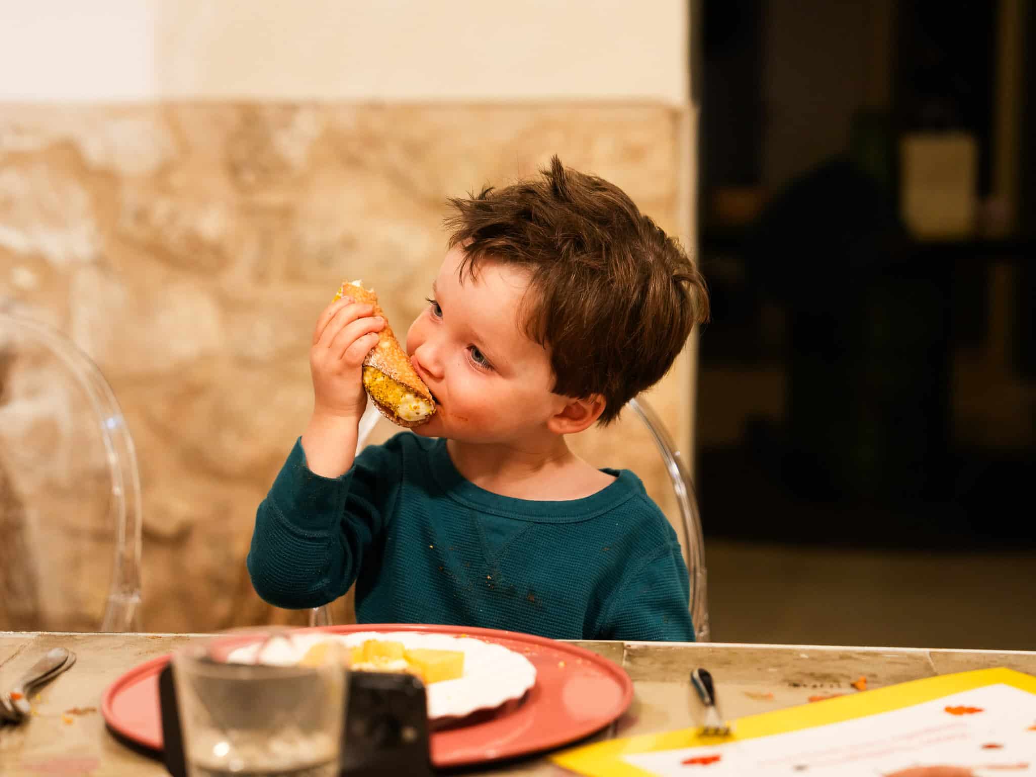boy eating cannoli at tenuta della cava, luxury villa in sicily