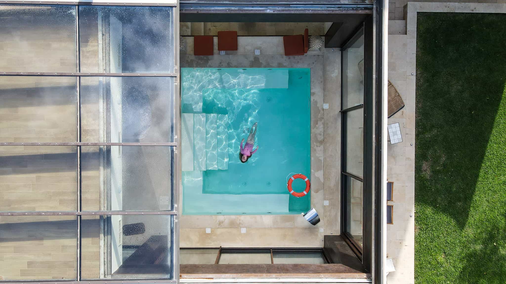 drone picture of girl swimming at tenuta della cava, retractable roof, luxury villa in sicily
